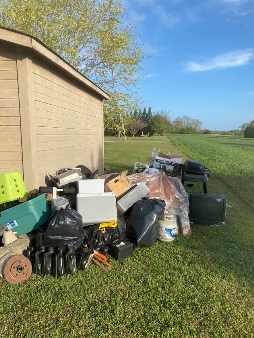 Mixed junk pile beside shed
