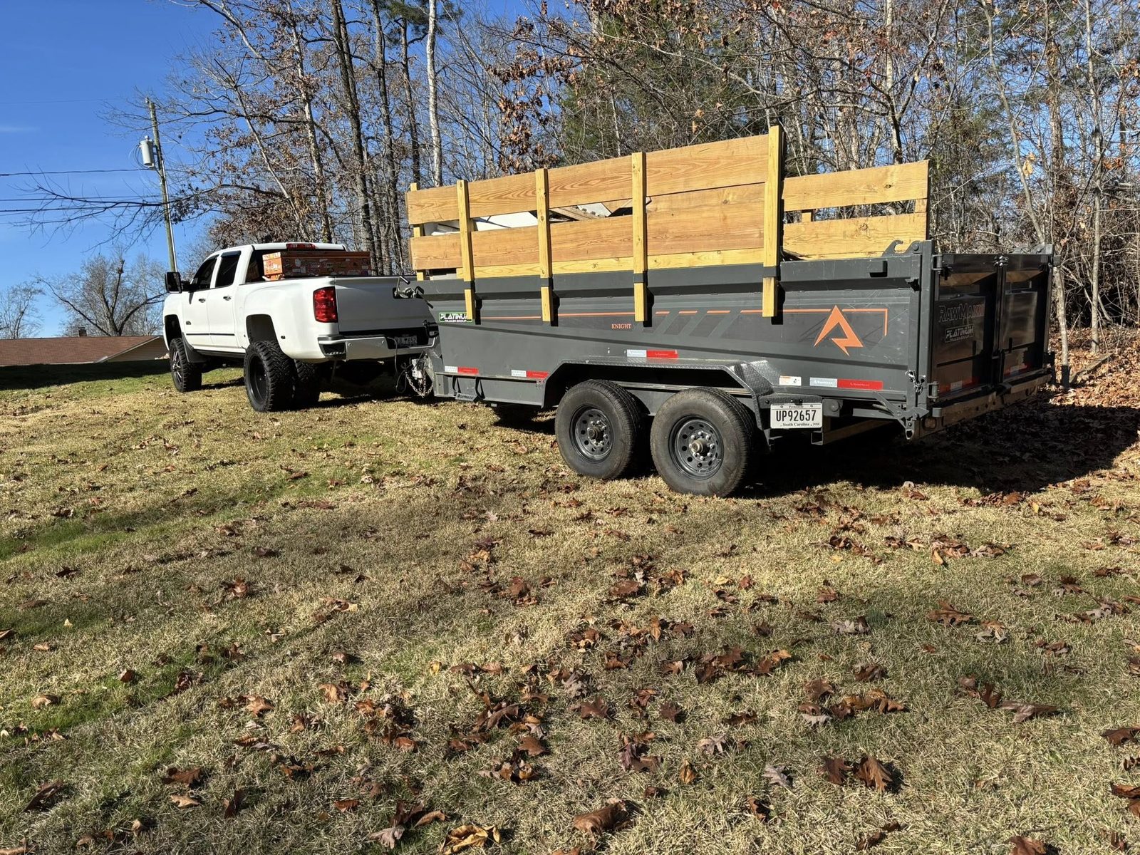 White Chevy truck with dump trailer