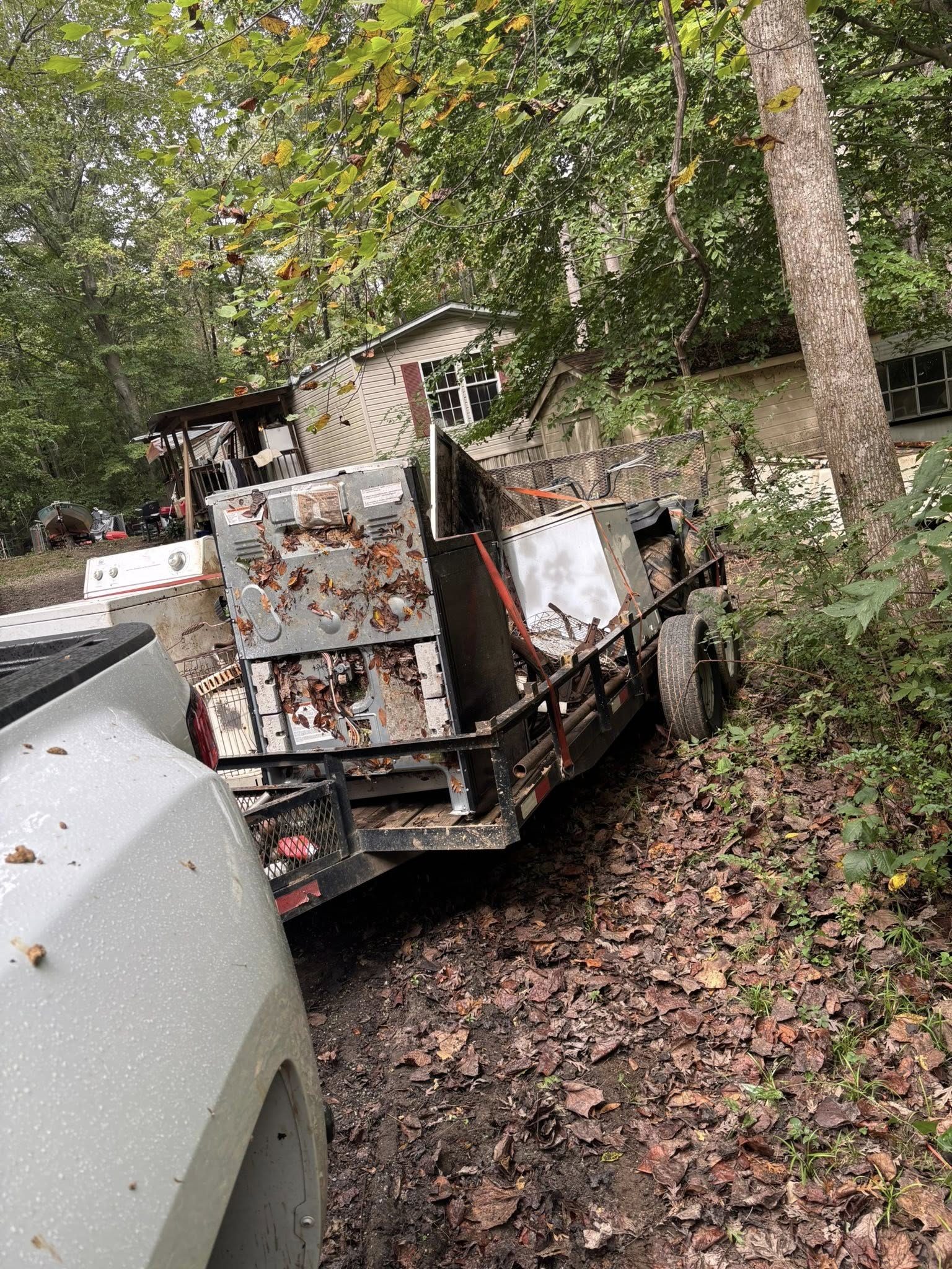Trailer loaded with appliances at wooded property